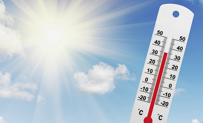 Am Himmel strahlende Sonne mit Thermometer über 30 Grad.
    