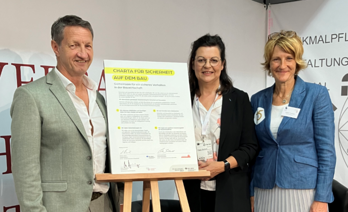 Drei Personen stehen neben der unterzeichneten Charta für Sicherheit. Markus Steininger, Bundesinnungsmeister vom Bundesverband Deutscher Steinmetze, Peggy Ruchatz, Referentin in der Hauptabteilung Prävention der BG BAU, und Sybille Trawinski, Geschäftsführerin des Bundesverbands Deutscher Steinmetze und Mitglied der ehrenamtlichen Vertreterversammlung der BG BAU (von links).
    