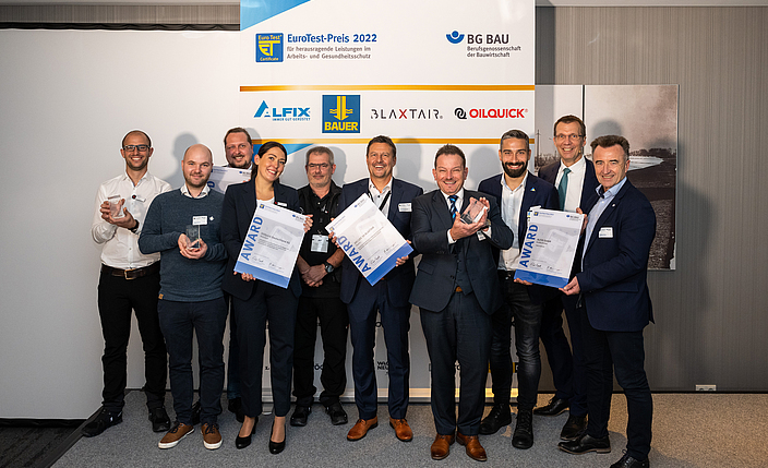 Auf dem Foto stehen Michael Kollmann (OilQuick Deutschland KG), Tobias Paucker (BAUER Maschinen GmbH), Dr. Alexander Weigl (BAUER Maschinen GmbH), Anna Betz (OilQuick Deutschland KG), Christian Rampp (OilQuick Deutschland KG), Dr. Frank Jörg Nieland (ARCURE SA BLAXTAIR), Andreas Meier (ALFIX GmbH), Stanislaw Schuster (ALFIX GmbH), Frank Werner (BG BAU), Wolfgang Kreis (BG BAU) nebeneinander.
    